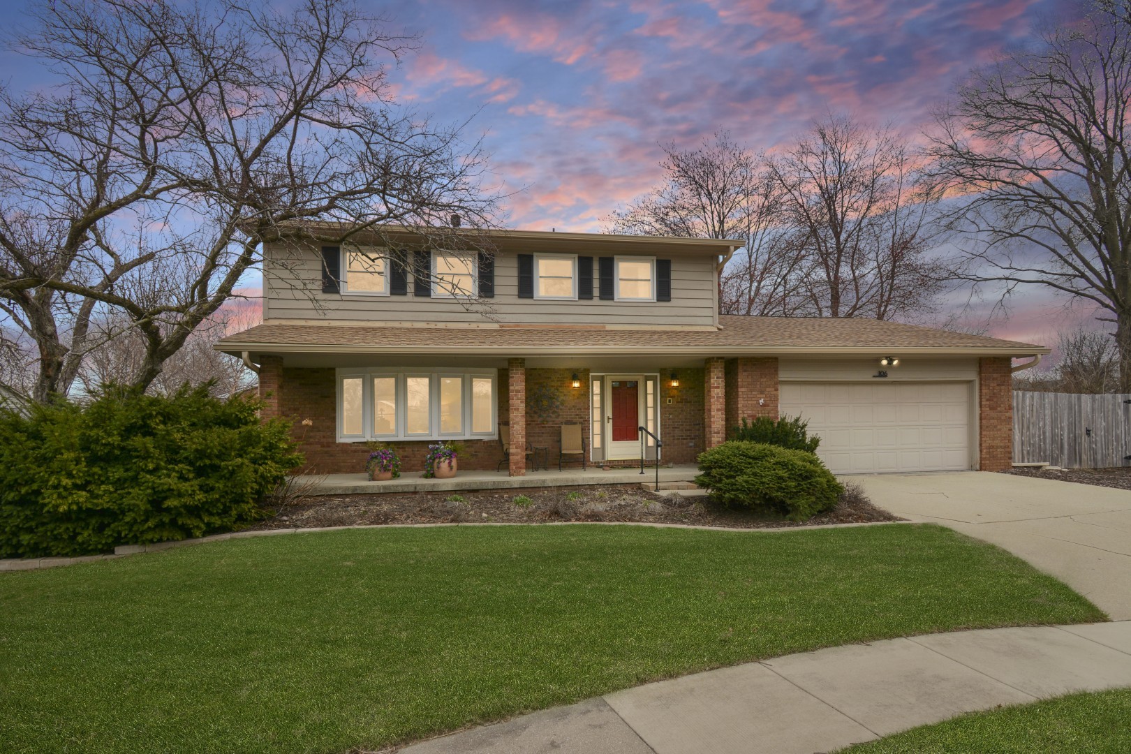 a front view of a house with a garden and plants