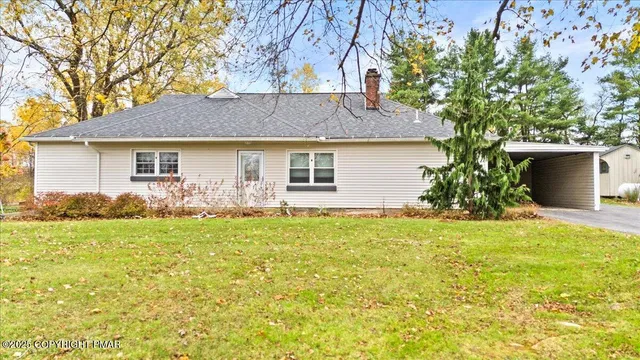 a front view of house with yard and trees