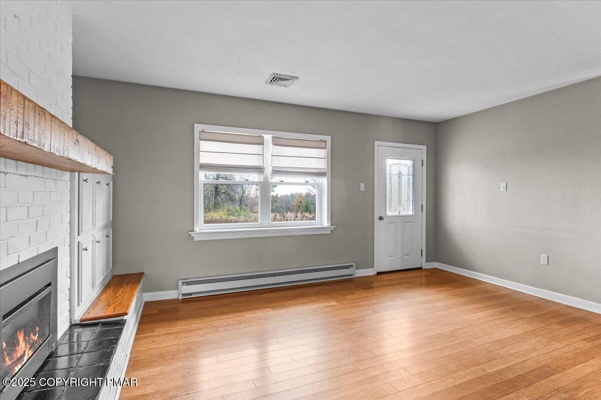 1215 Country Club Road Clarks Summit, PA 18411 - Photo 14 of 50 a view of an empty room with a window and wooden floor