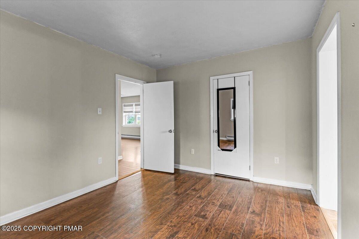 1215 Country Club Road Clarks Summit, PA 18411 - Photo 19 of 50 an empty room with wooden floor and mirror
