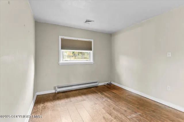 a view of a room with wooden floor and a window