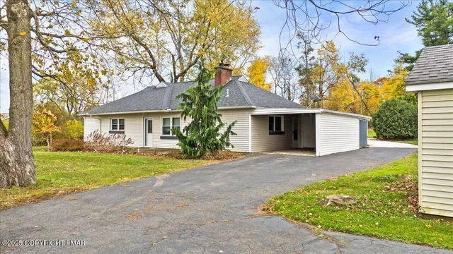 front view of a house with a yard and an trees