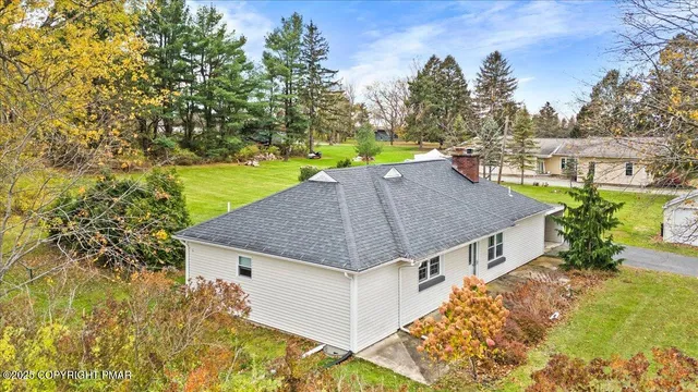 a aerial view of a house with a yard table and chairs
