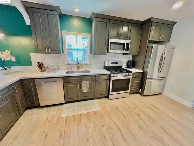 a kitchen with stainless steel appliances granite countertop a sink stove and refrigerator