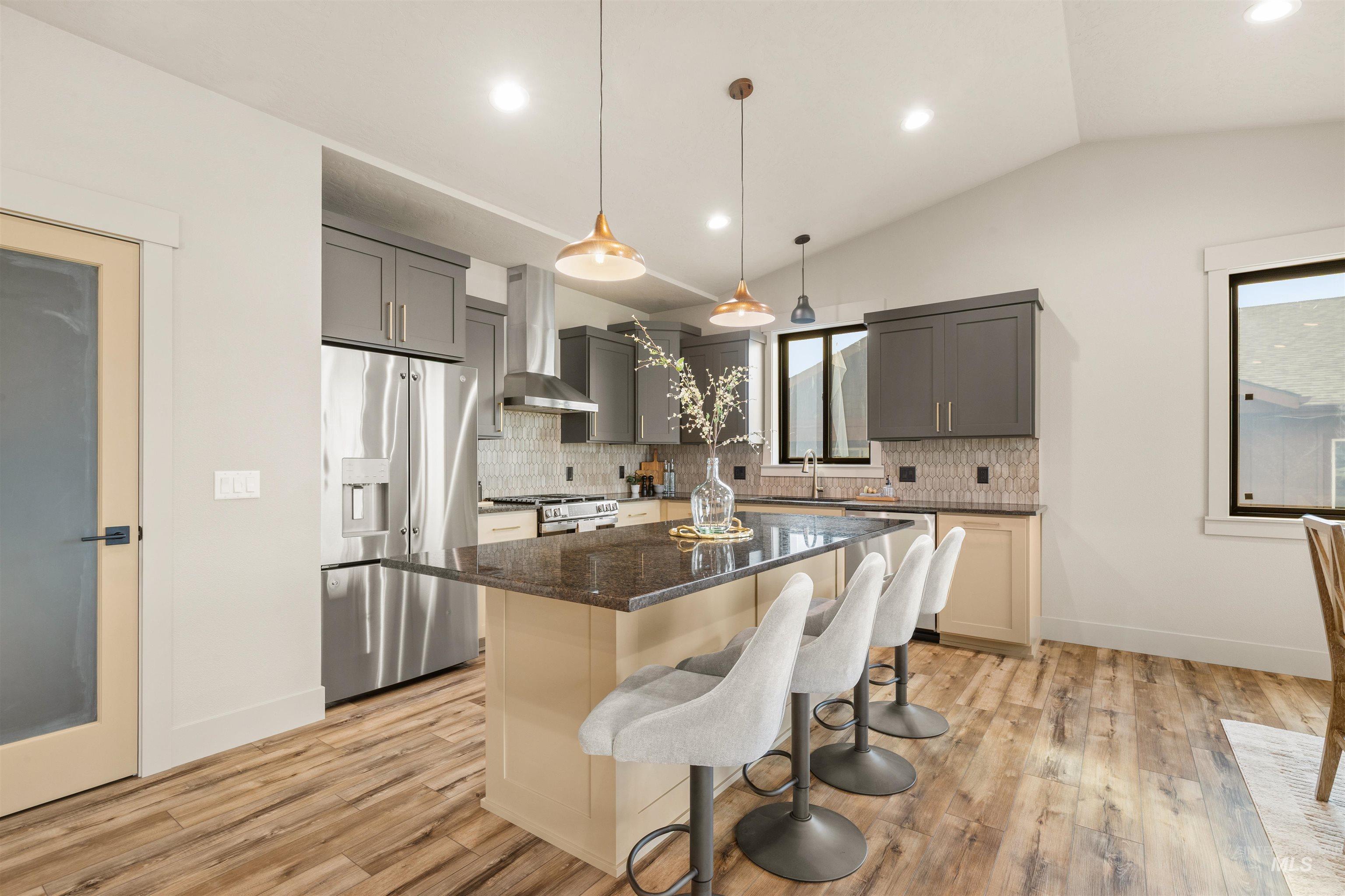 335 Warner Avenue Lewiston, ID 83501 - Photo 18 of 43 Kitchen with stainless steel appliances, a kitchen breakfast bar, pendant lighting, dark stone countertops, and light wood-style flooring
