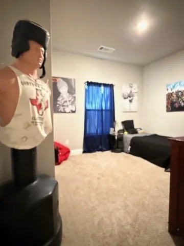 a bedroom with a bed and a painting on the wall