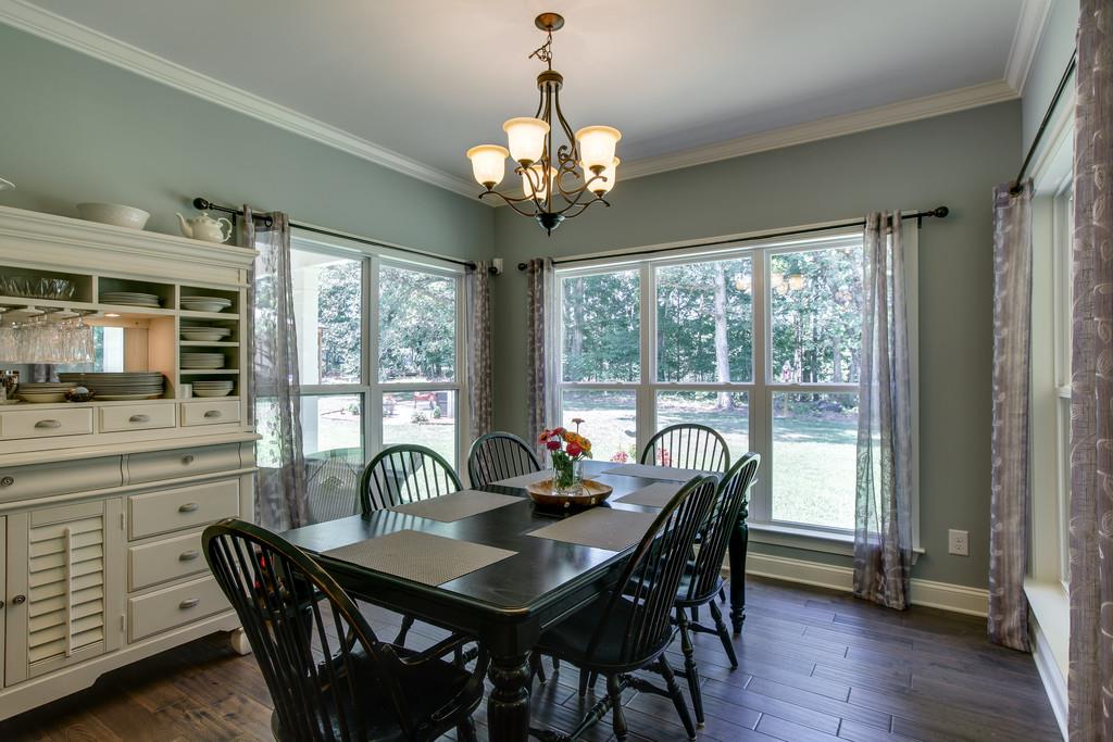 7901 Pinewood Road Fairview, TN 37062 - Photo 17 of 30 a dining room with furniture a chandelier and wooden floor
