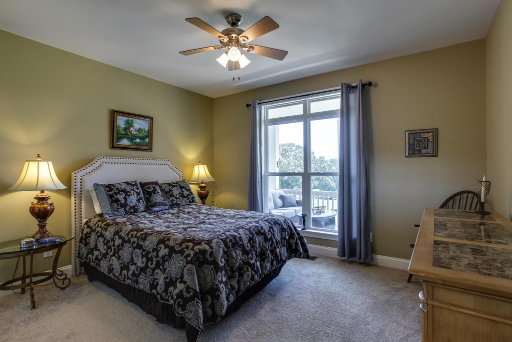7901 Pinewood Road Fairview, TN 37062 - Photo 23 of 30 a bedroom with a bed chandelier and a window