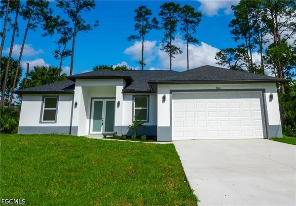 a front view of a house with a yard and garage