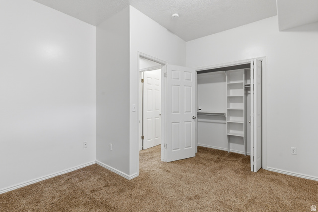 134 West 475 South Ogden, UT 84404 - Photo 18 of 27 Unfurnished bedroom with a closet, carpet floors, and a textured ceiling