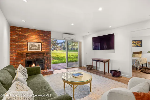 a living room with furniture a fireplace and a flat screen tv