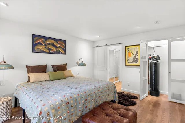 a bedroom with a bed and a refrigerator