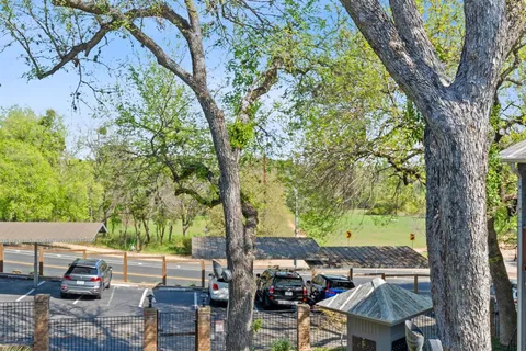 a view of a patio with table and chairs under an large tree