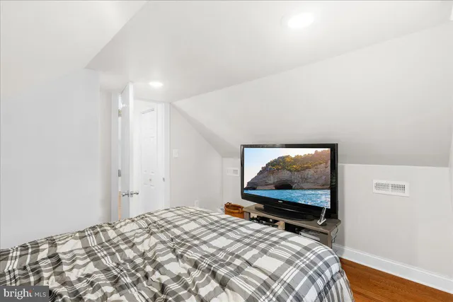 a bedroom with a bed and a flat screen tv