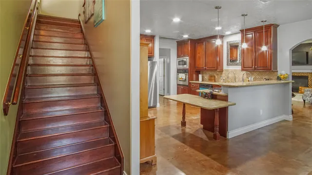 a kitchen with kitchen island a sink stainless steel appliances and cabinets