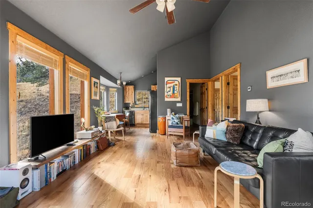 a living room with furniture a flat screen tv and large windows