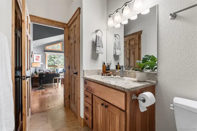 a bathroom with a granite countertop sink a mirror and vanity