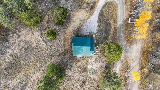 a aerial view of a house with a yard and large tree