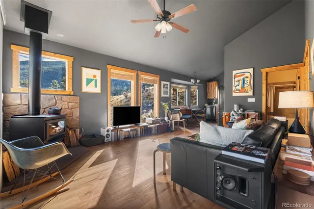 a living room with furniture a flat screen tv and a floor to ceiling window