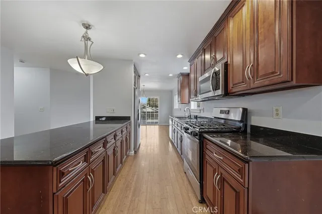 a kitchen with stainless steel appliances granite countertop a stove a sink and a refrigerator