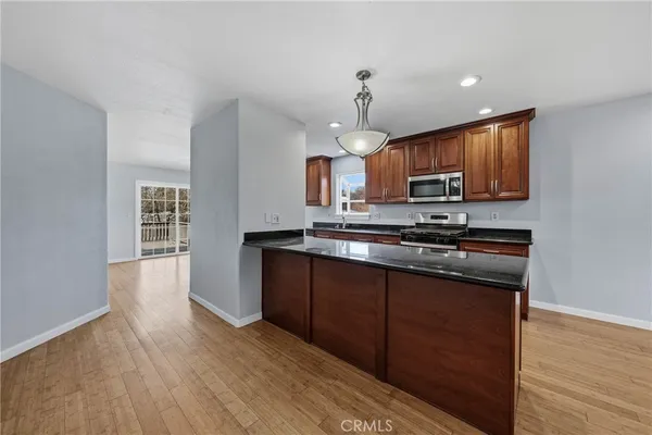a kitchen with stainless steel appliances granite countertop a sink a stove and a microwave