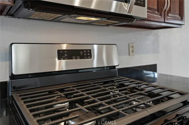 a kitchen with stainless steel appliances granite countertop a stove microwave and cabinets