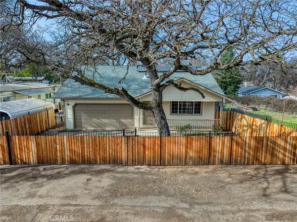 a front view of a house with a yard and wooden fence