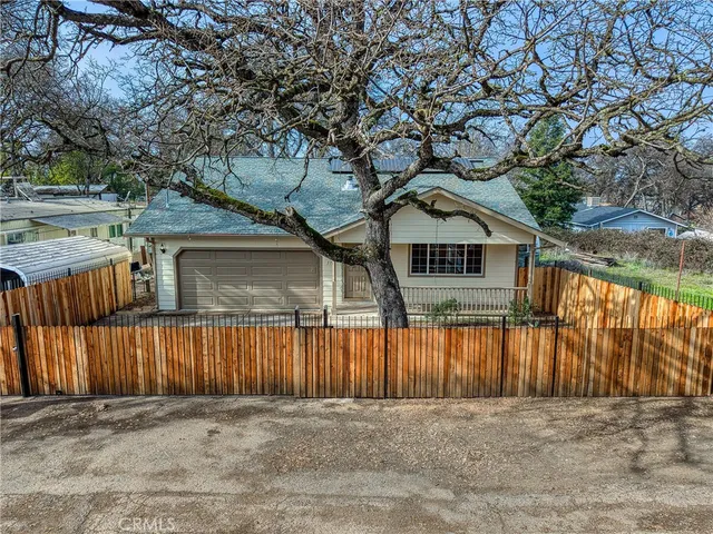 a front view of a house with a yard and wooden fence