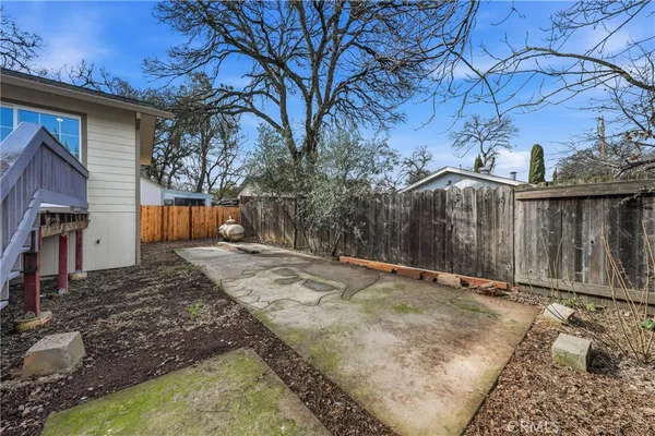 a view of a yard with wooden fence and a tree