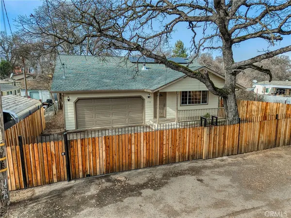 a front view of a house with a tree