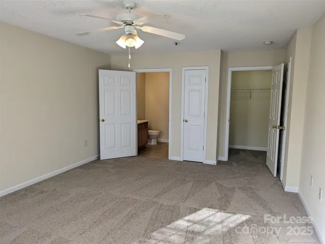 an empty room with a ceiling fan and a bathroom