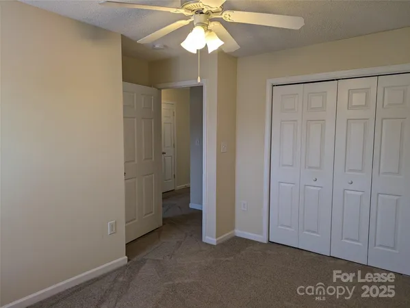 an empty room with a ceiling fan and a window