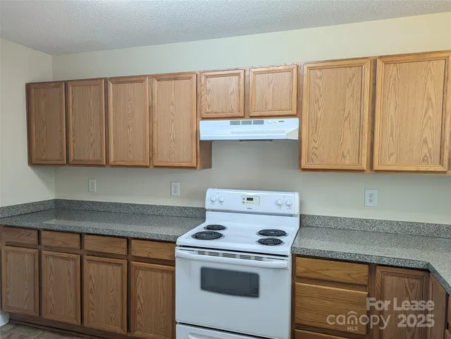 a kitchen with granite countertop white cabinets and white appliances
