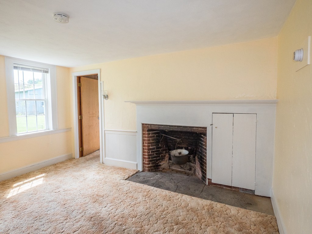 32 Old County Road Southampton, MA 01073 - Photo 10 of 23 an empty room with a fireplace and window
