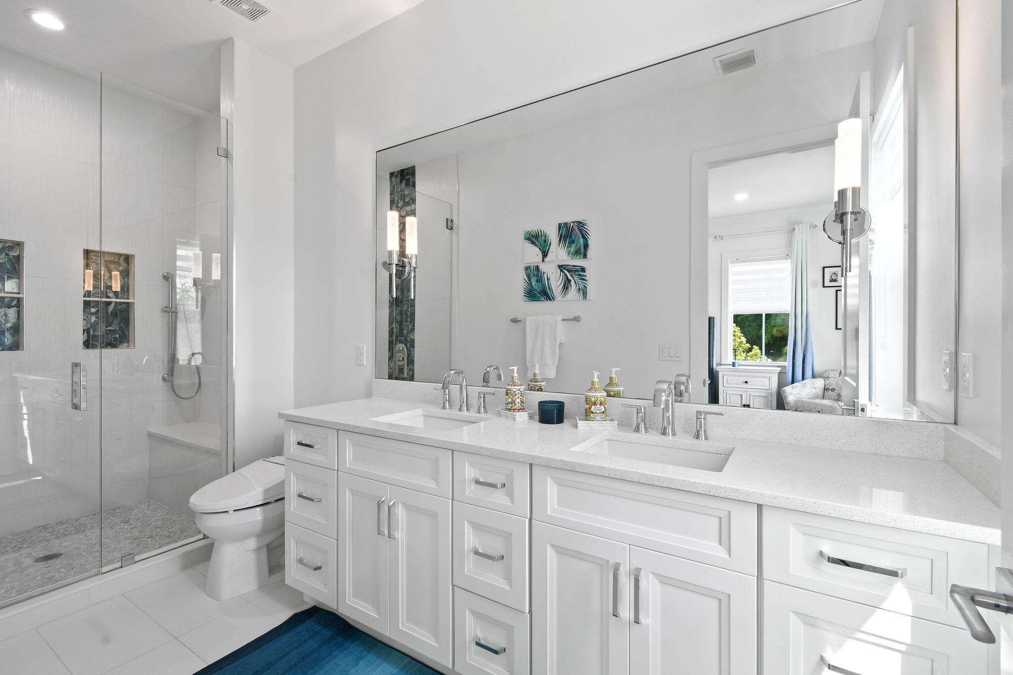4707 Southeast Manatee Terrace Stuart, FL 34997 - Photo 22 of 68 a bathroom with a double vanity sink toilet and shower