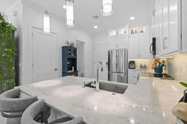 a kitchen with kitchen island a sink stainless steel appliances and cabinets