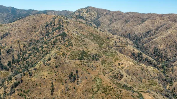 a view of a dry yard with mountains in the background