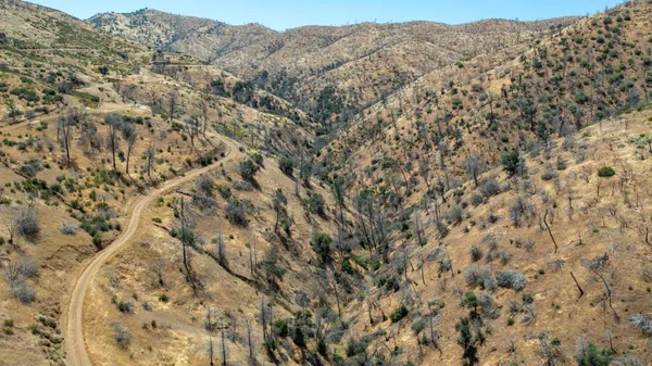 a view of a dry yard with mountains in the background