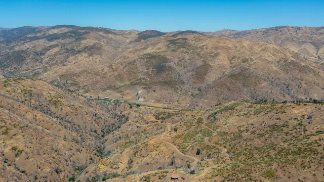 a view of a dry yard with mountains in the background
