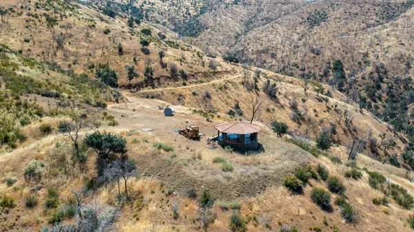 a view of a dry yard with mountains in the background