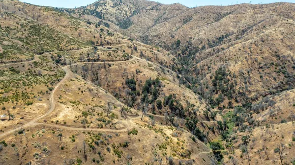 a view of a dry yard with mountains in the background