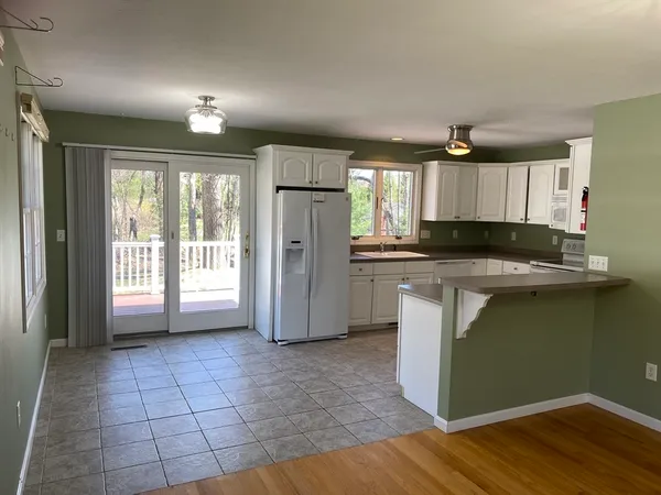 a kitchen with granite countertop a refrigerator and a stove top oven