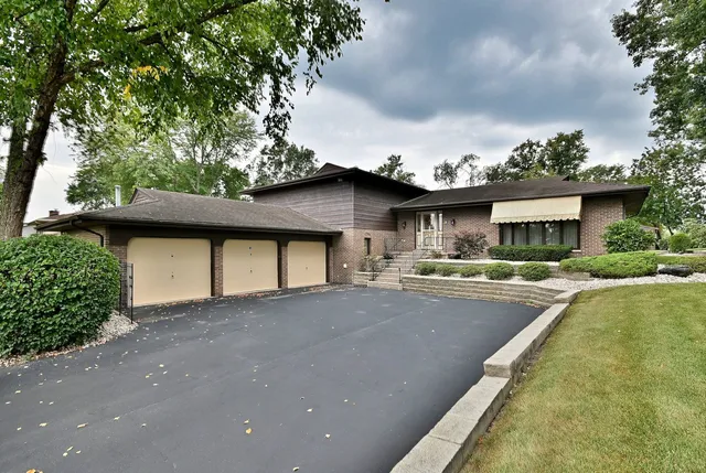 a front view of a house with a yard garage and outdoor seating