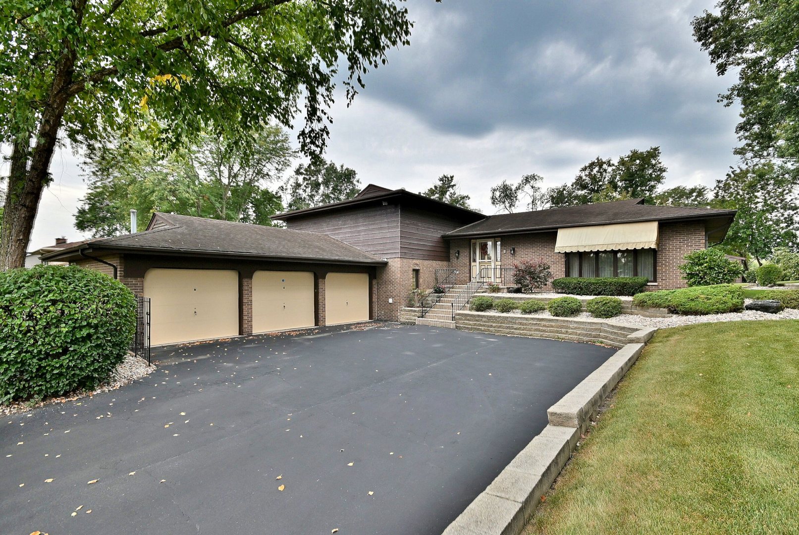 a front view of a house with a yard garage and outdoor seating
