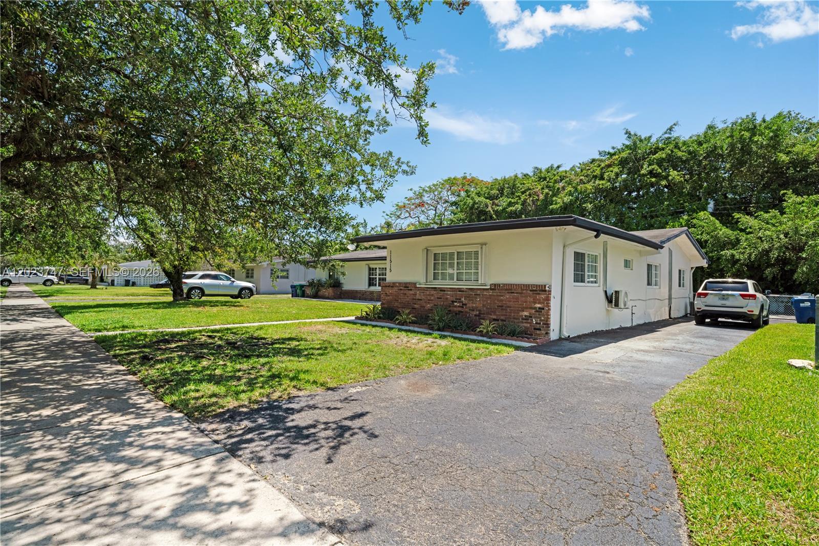 11515 Southwest 81st Road, Unit 11515 Pinecrest, FL 33156 - Photo 2 of 33 a front view of a house with a yard and garage