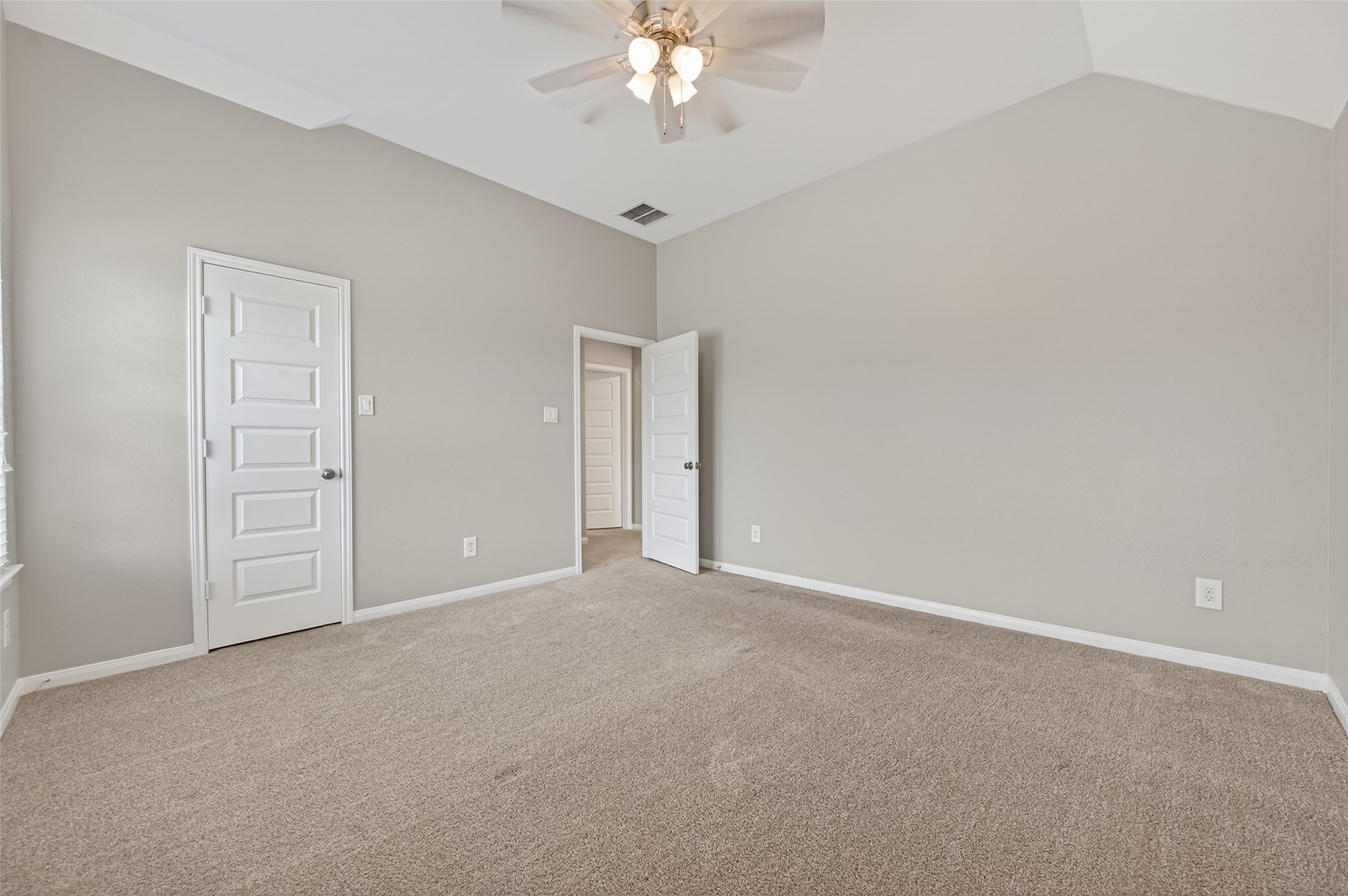 7003 Bristol Memorial Drive Spring, TX 77379 - Photo 31 of 40 Generously sized secondary bedroom featuring soaring vaulted ceilings that enhance the open, airy feel. Large windows provide abundant natural light and neighborhood views, while neutral tones and plush carpeting create a versatile space ready to fit a variety of needs. This well-proportioned bedroom offers flexibility and comfort, complementing the thoughtful layout of this Spring TX home.