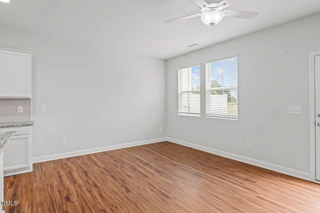 a view of a room with wooden floor and fan
