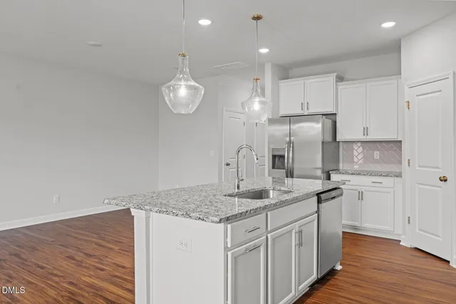 a kitchen with stainless steel appliances granite countertop a sink a stove a microwave oven a sink with cabinets and wooden floor