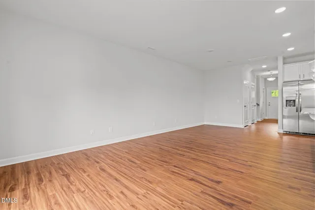 a view of empty room with wooden floor