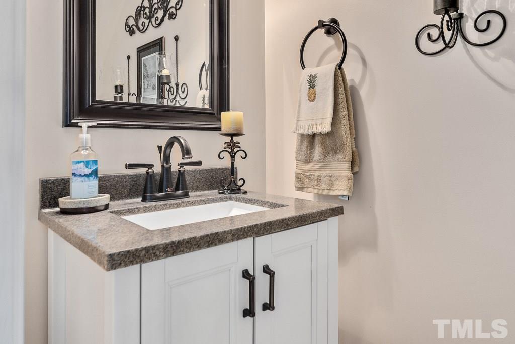 8348 City Loft Court Raleigh, NC 27613 - Photo 11 of 24 a bathroom with a granite countertop sink and a mirror